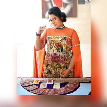 Dr. Neetti Katyal standing behind a fan of tarot cards.